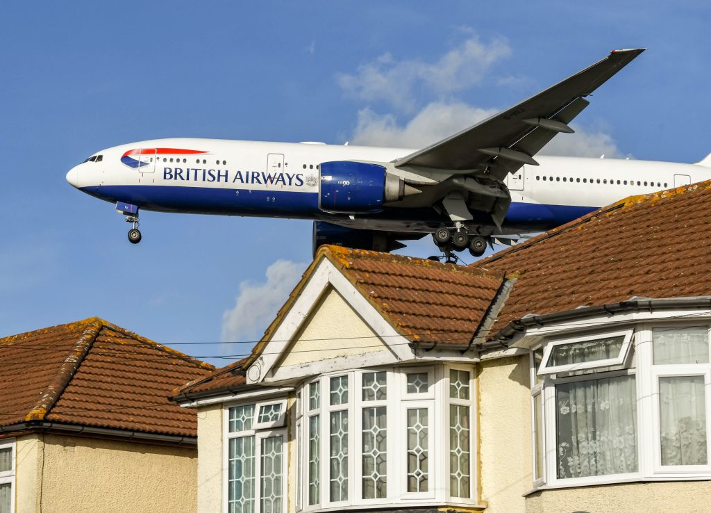 British Airways Boeing 777 flying over roofs